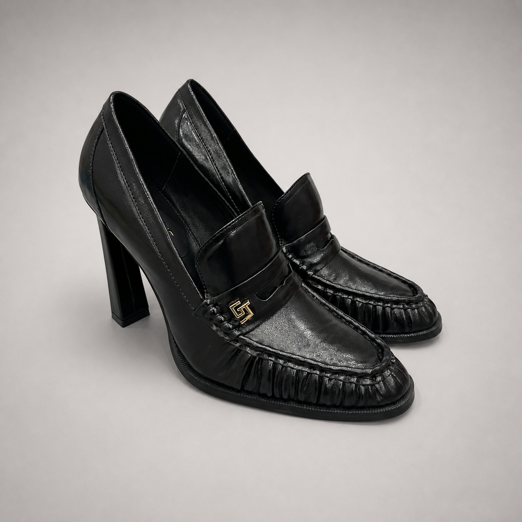 Black high-heeled loafer pair three-quarter view showing a loafer-inspired vamp and block heel