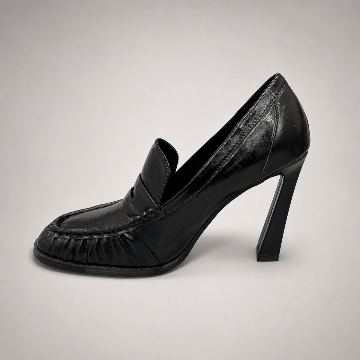 Black high-heeled loafer opposite side profile showing a loafer-inspired vamp and block heel