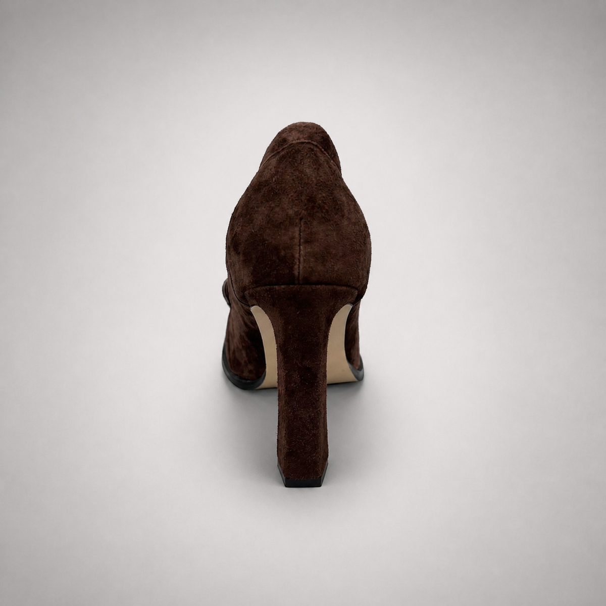 Brown high-heeled loafer rear view showing a loafer-inspired vamp and block heel