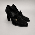Black high-heeled loafer pair three-quarter view showing a loafer-inspired vamp and block heel