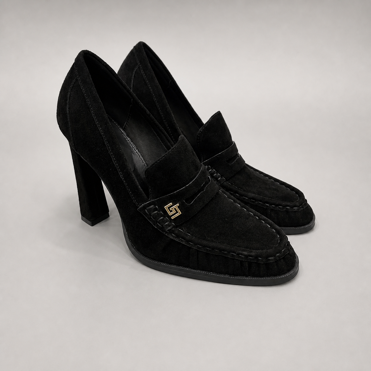 Black high-heeled loafer pair three-quarter view showing a loafer-inspired vamp and block heel