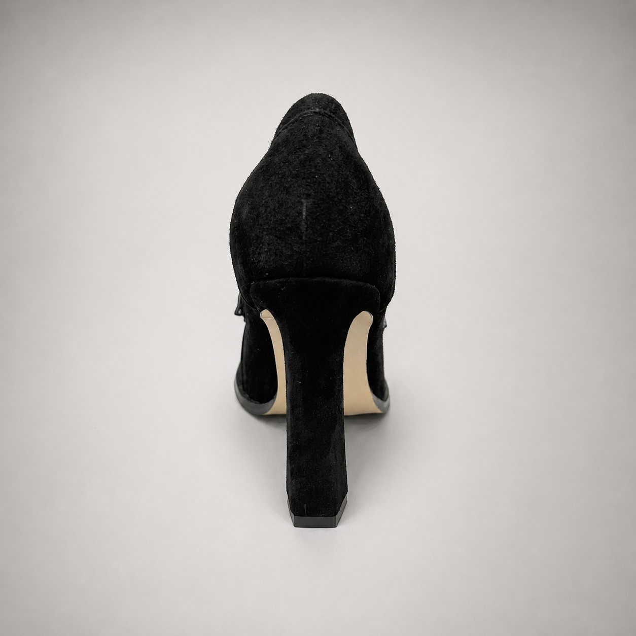 Black high-heeled loafer rear view showing a loafer-inspired vamp and block heel