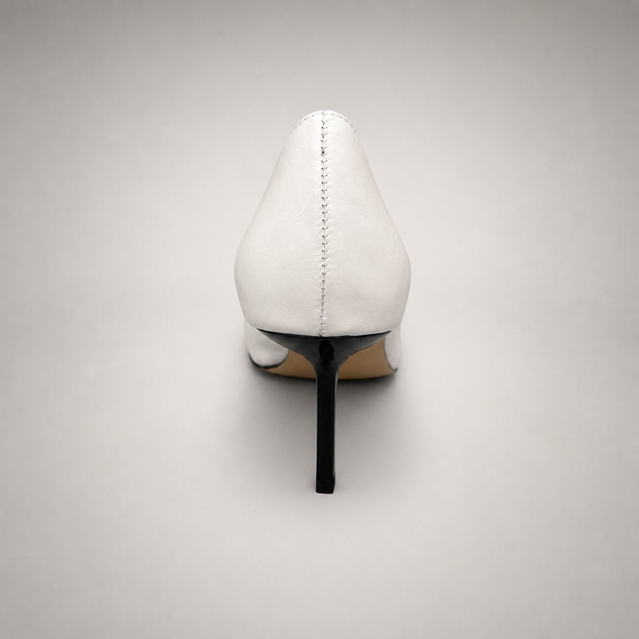 White pump rear view showing a square toe, slingback strap, and metal accent