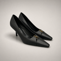 Black pump pair three-quarter view showing a square toe, slingback strap, and metal accent