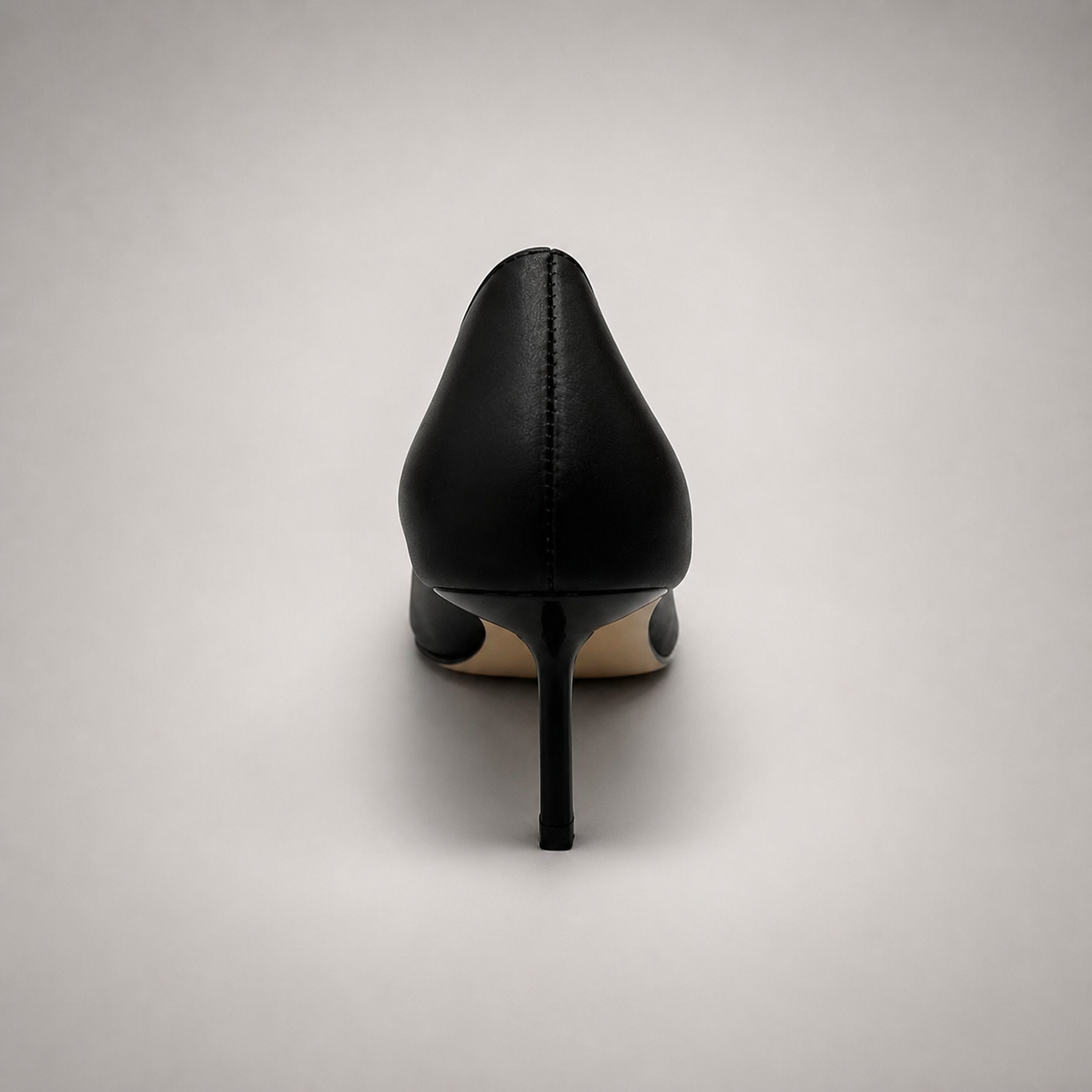 Black pump rear view showing a square toe, slingback strap, and metal accent