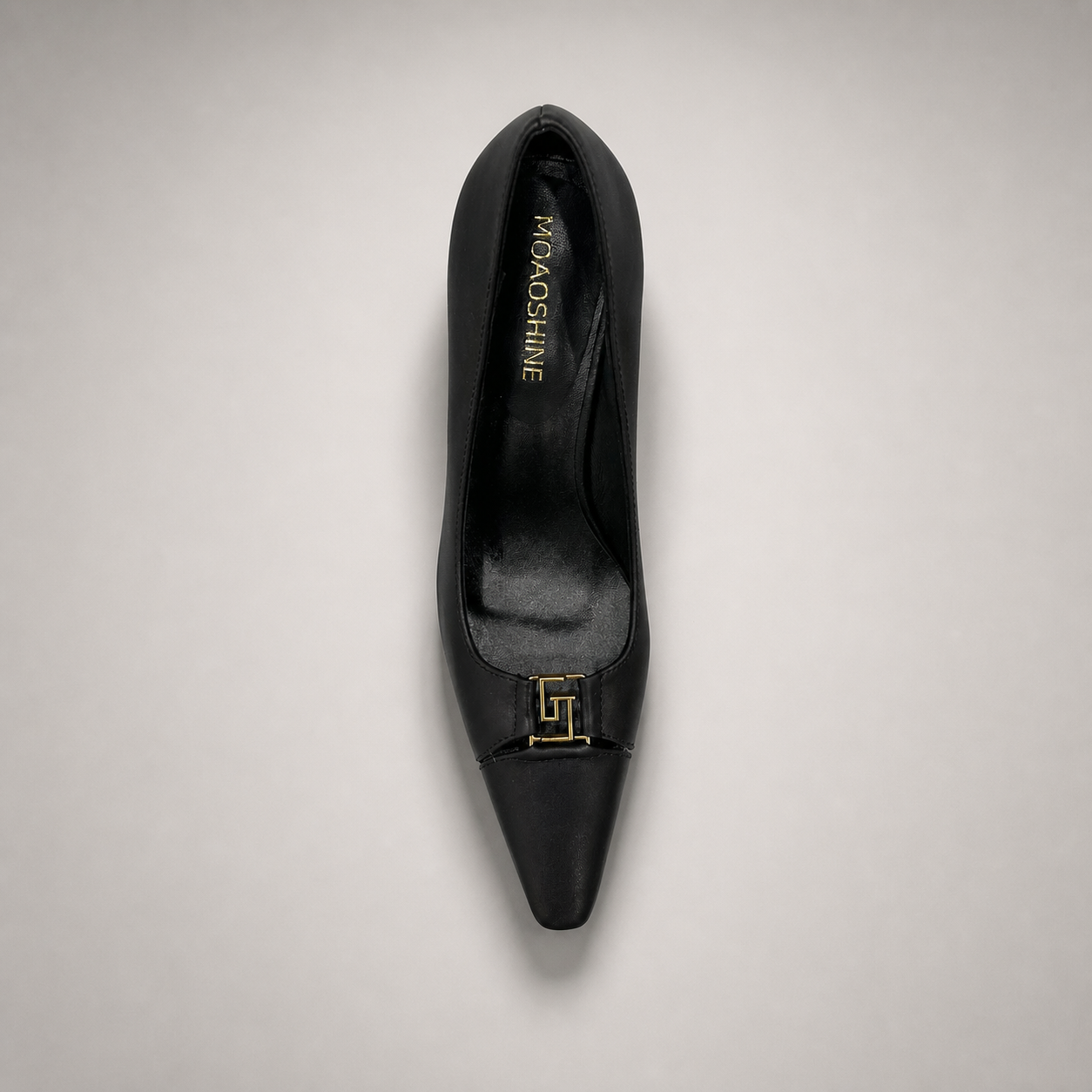 Black pump top view showing a square toe, slingback strap, and metal accent