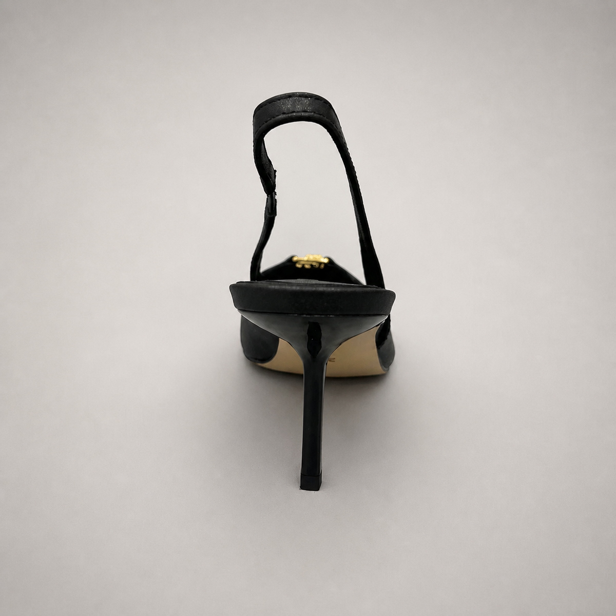Black slingback pump rear view showing a square toe, slingback strap, and metal accent