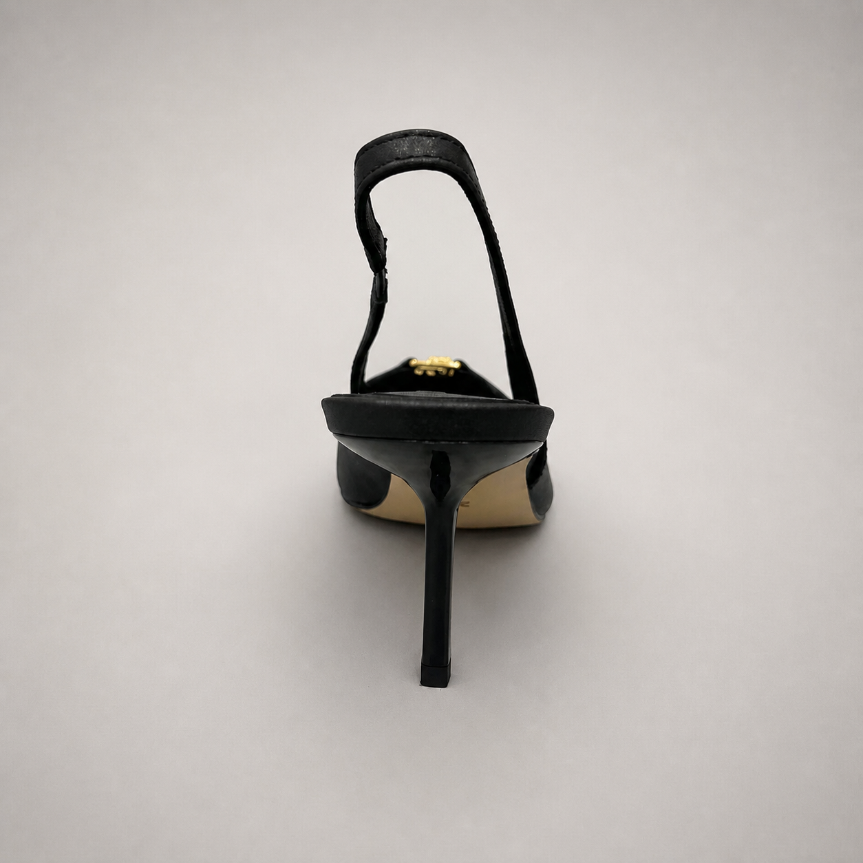 Black slingback pump rear view showing a square toe, slingback strap, and metal accent