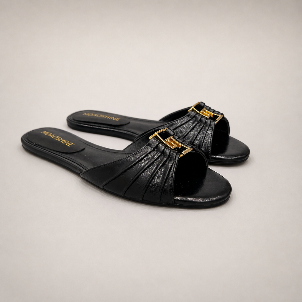 Black slide sandal pair three-quarter view showing a pleated forefoot strap