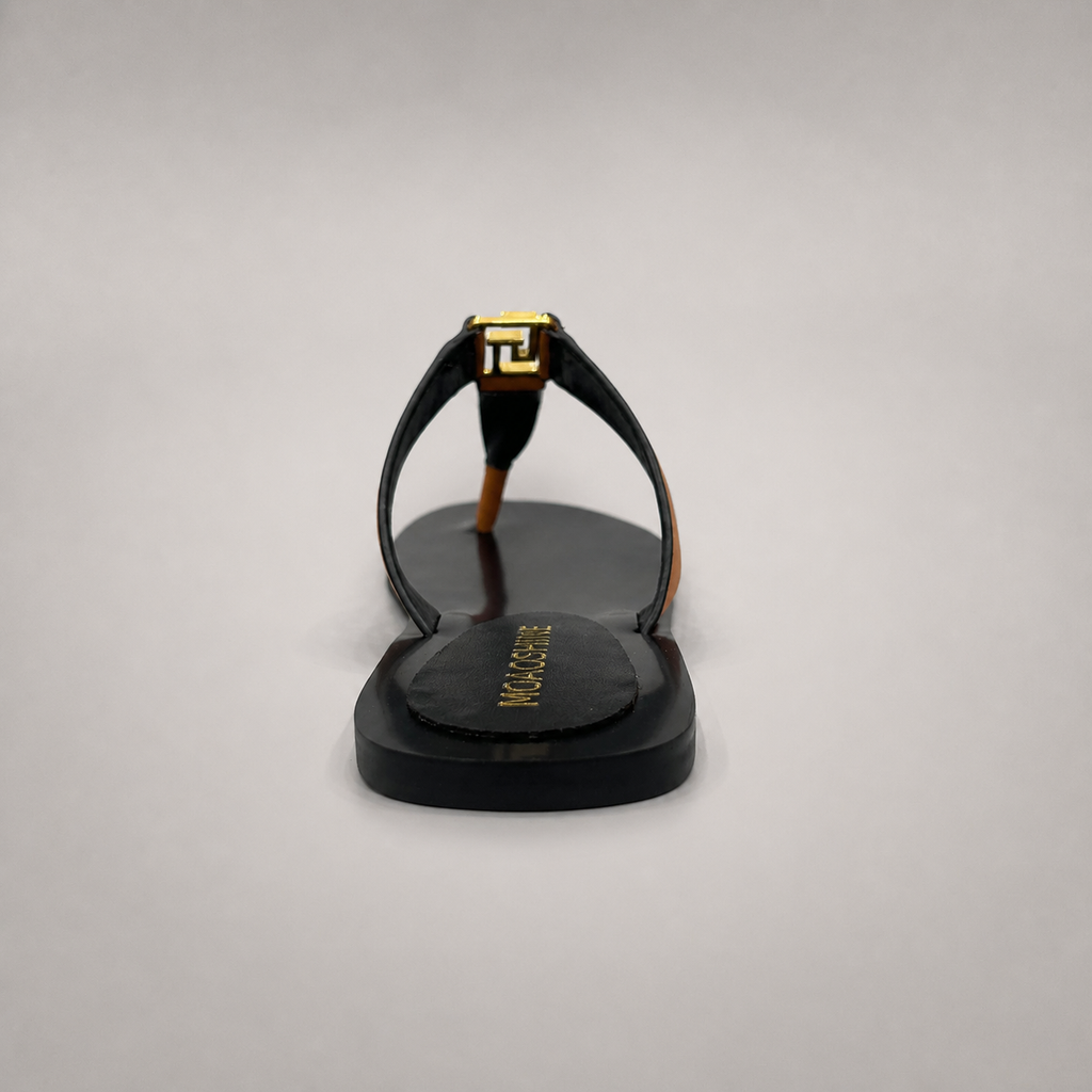 Brown flat sandal rear view showing a flat sole with a toe-loop strap