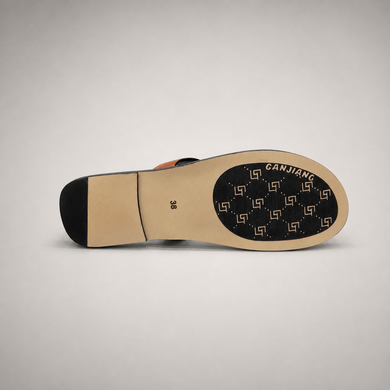 Brown flat sandal outsole view showing the cow leather outsole