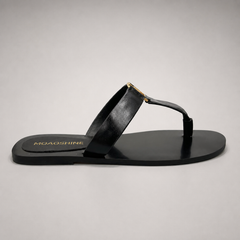 Black flat sandal side profile showing a flat sole with a toe-loop strap