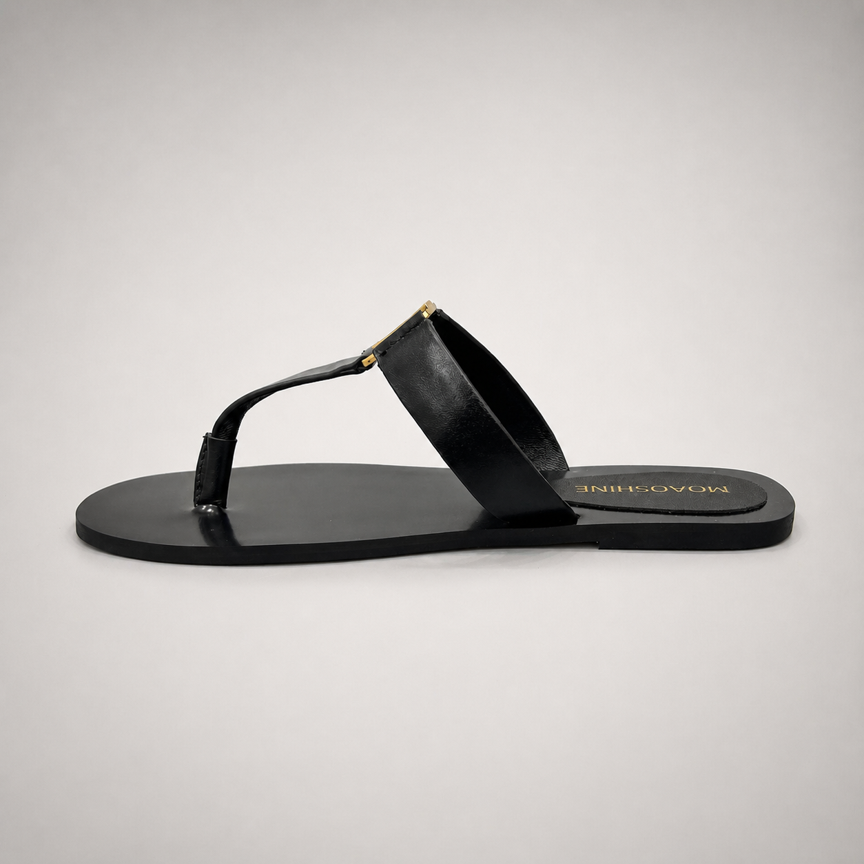 Black flat sandal opposite side profile showing a flat sole with a toe-loop strap