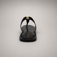Black flat sandal rear view showing a flat sole with a toe-loop strap