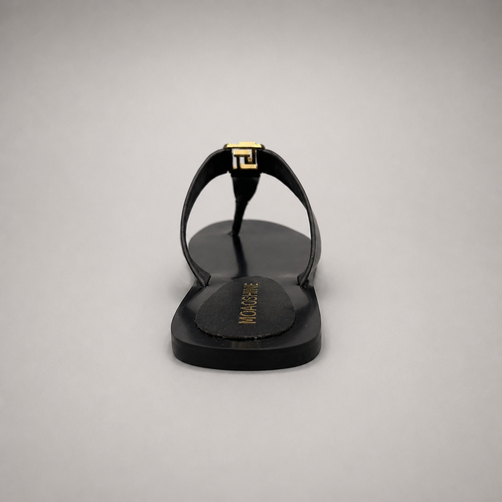 Black flat sandal rear view showing a flat sole with a toe-loop strap