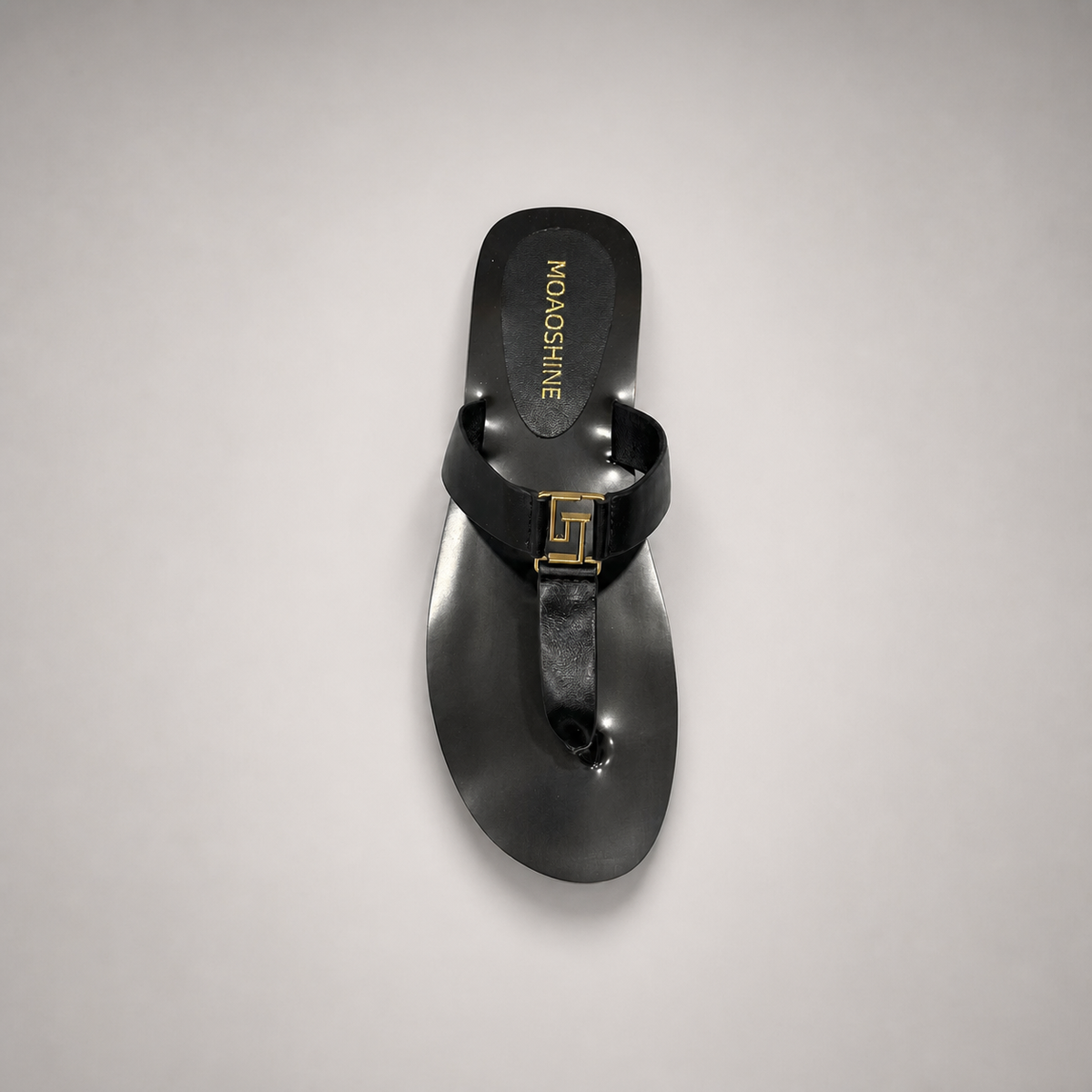 Black flat sandal top view showing a flat sole with a toe-loop strap