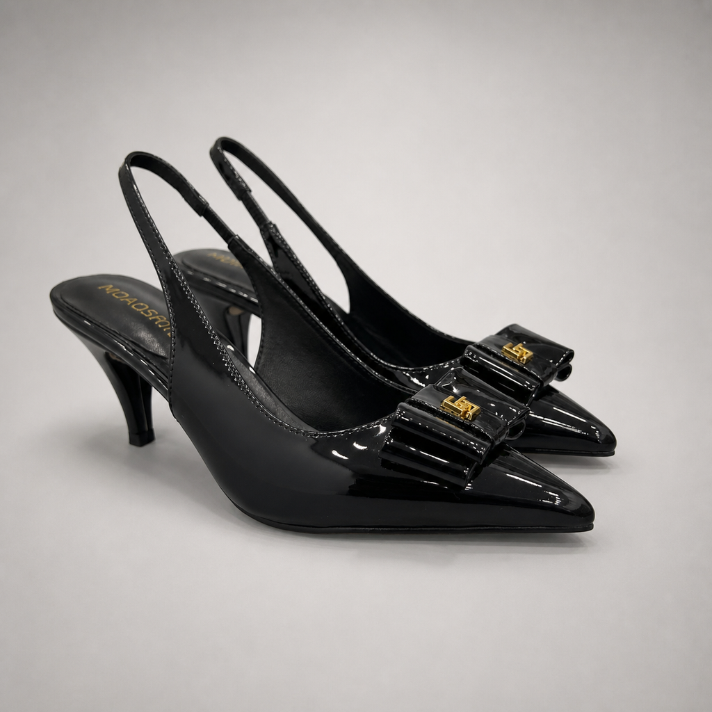 Black slingback pump pair three-quarter view showing a pointed toe and bow-shaped vamp ornament
