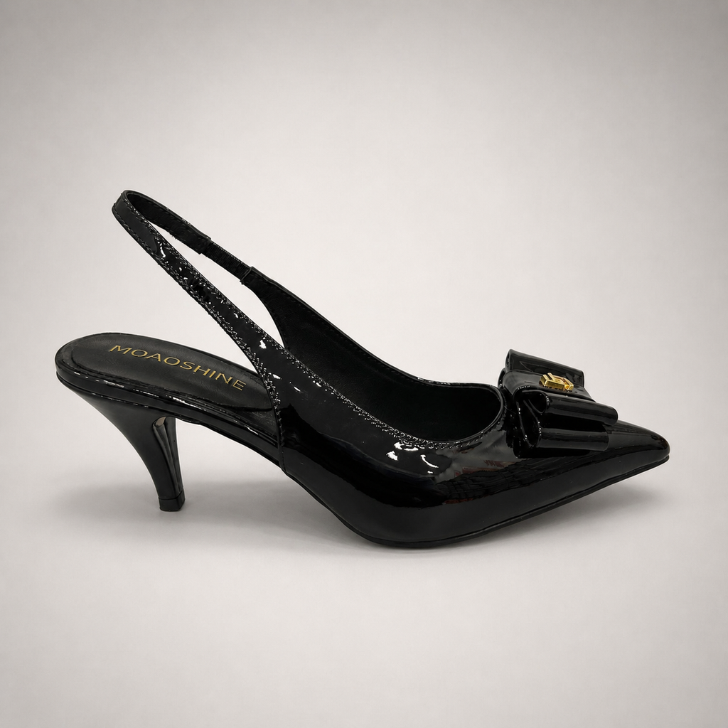 Black slingback pump side profile showing a pointed toe and bow-shaped vamp ornament