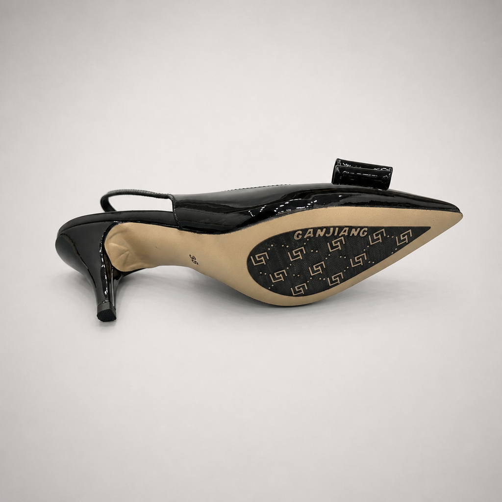 Black slingback pump rear view showing a pointed toe and bow-shaped vamp ornament