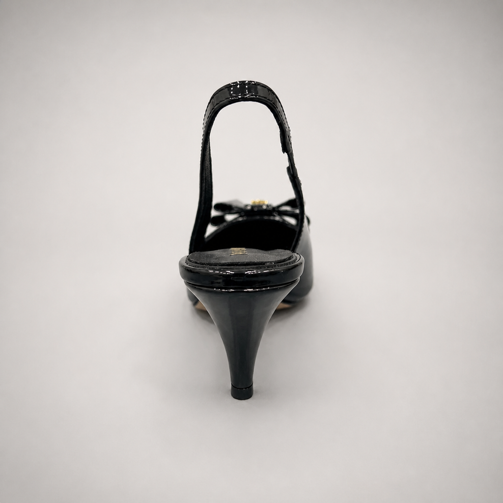 Black slingback pump top view showing a pointed toe and bow-shaped vamp ornament