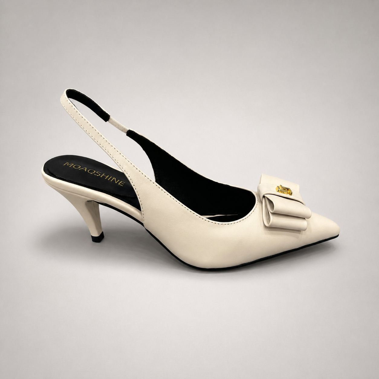 Ivory slingback pump side profile showing a pointed toe and bow-shaped vamp ornament