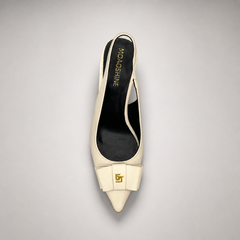 Ivory slingback pump top view showing a pointed toe and bow-shaped vamp ornament