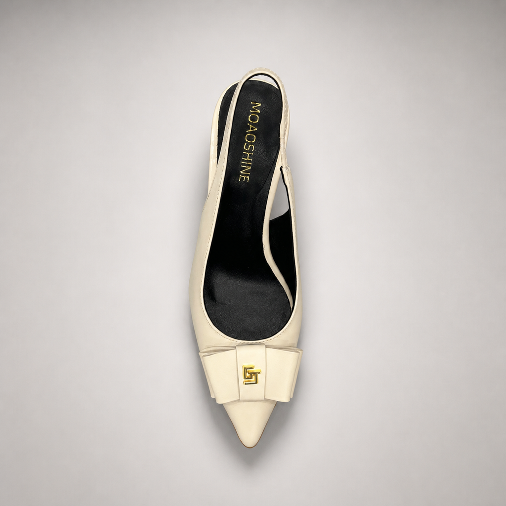 Ivory slingback pump top view showing a pointed toe and bow-shaped vamp ornament