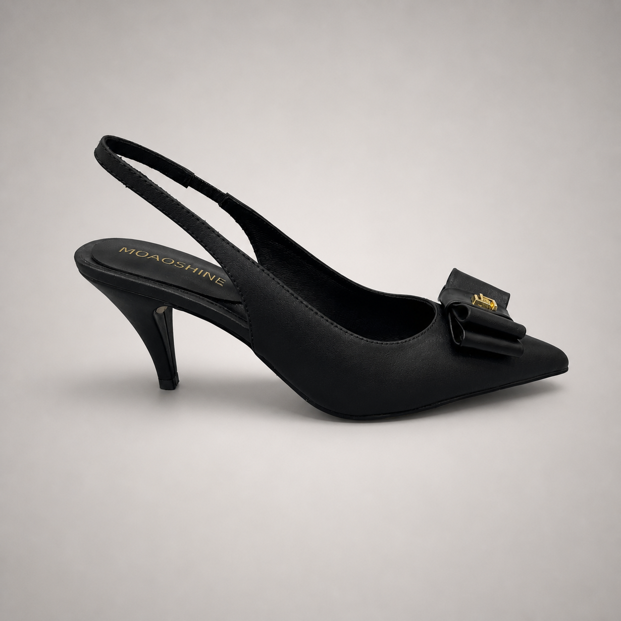 Black slingback pump side profile showing a pointed toe and bow-shaped vamp ornament