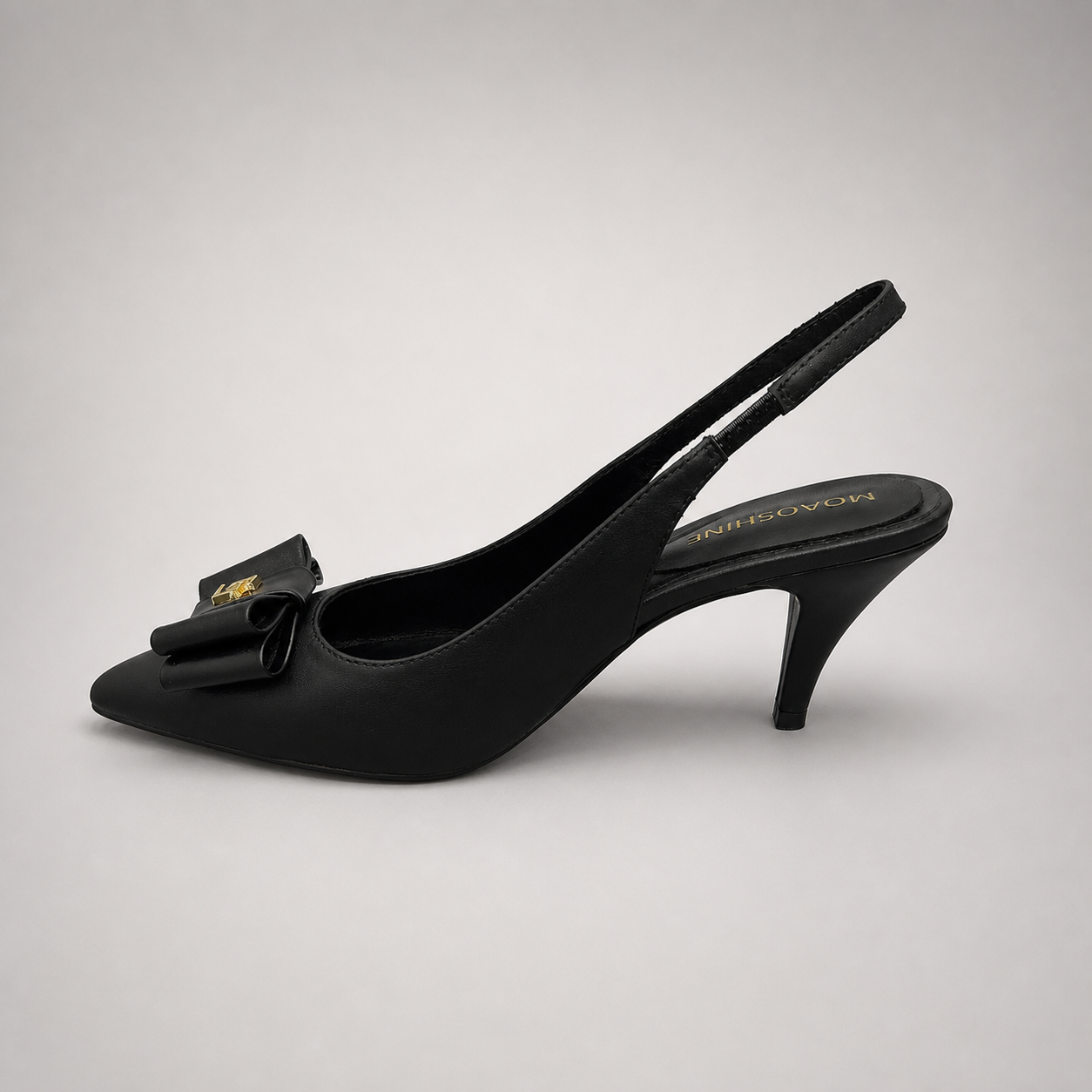 Black slingback pump opposite side profile showing a pointed toe and bow-shaped vamp ornament