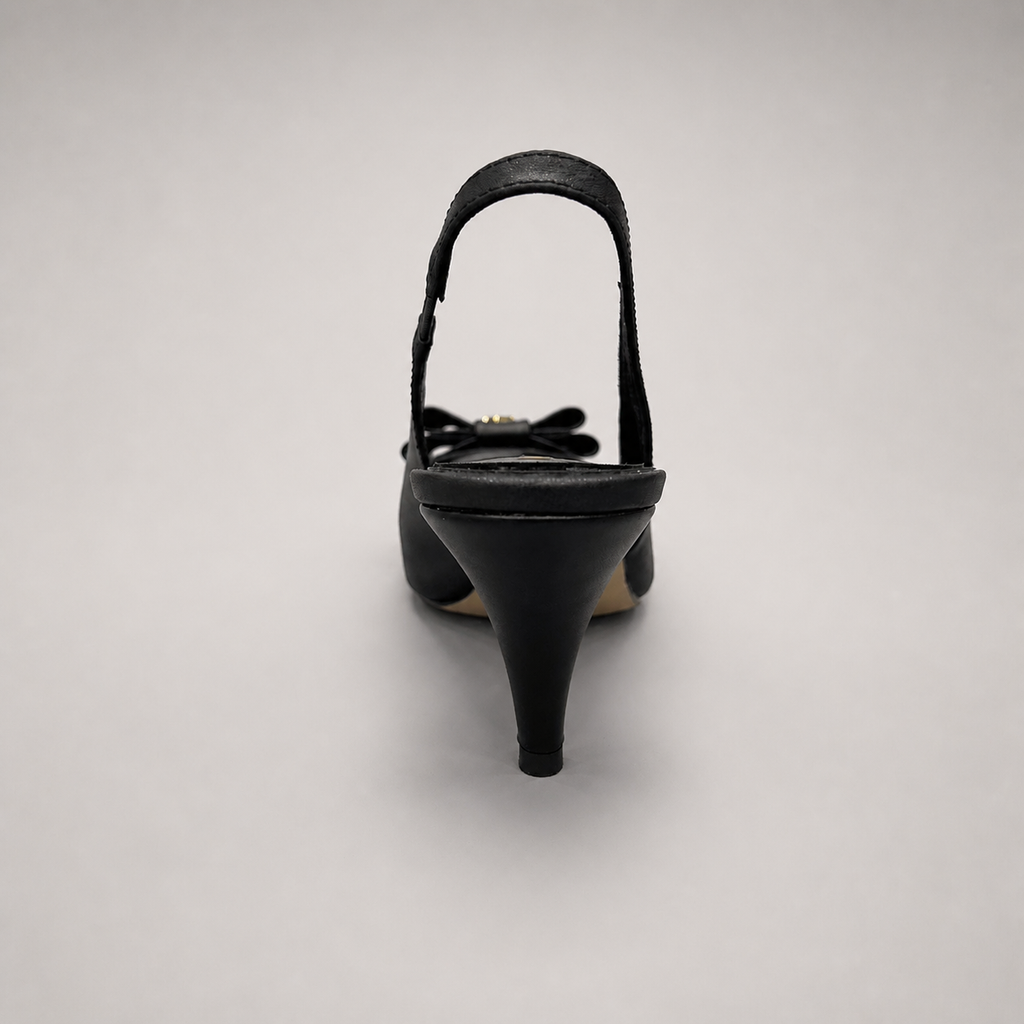 Black slingback pump rear view showing a pointed toe and bow-shaped vamp ornament