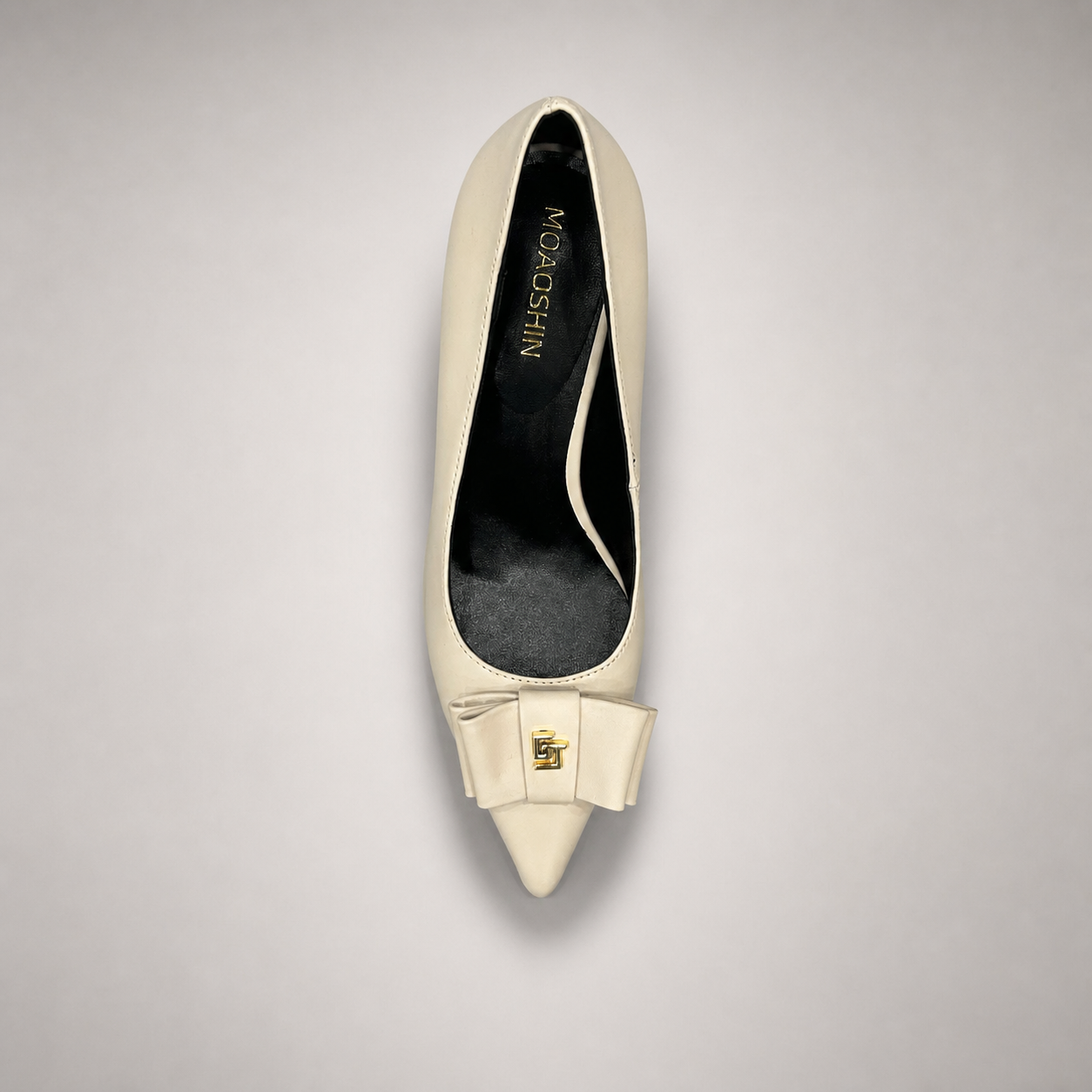Ivory pump top view showing a pointed toe and bow-shaped vamp ornament