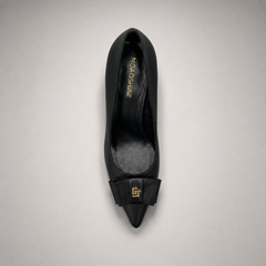 Black pump top view showing a pointed toe and bow-shaped vamp ornament