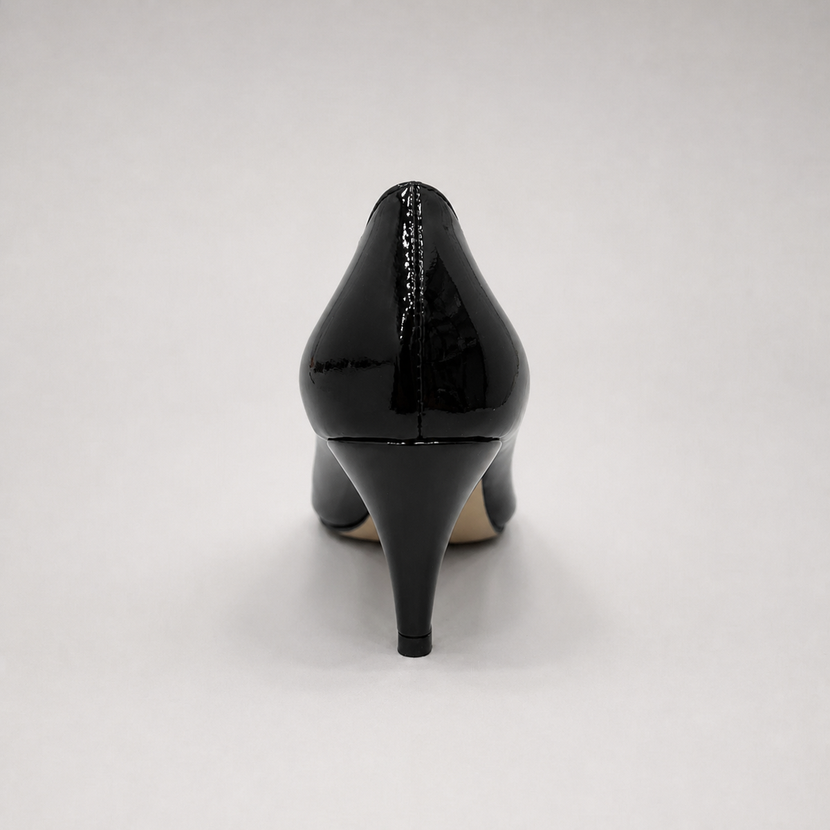 Black pump rear view showing a pointed toe and bow-shaped vamp ornament