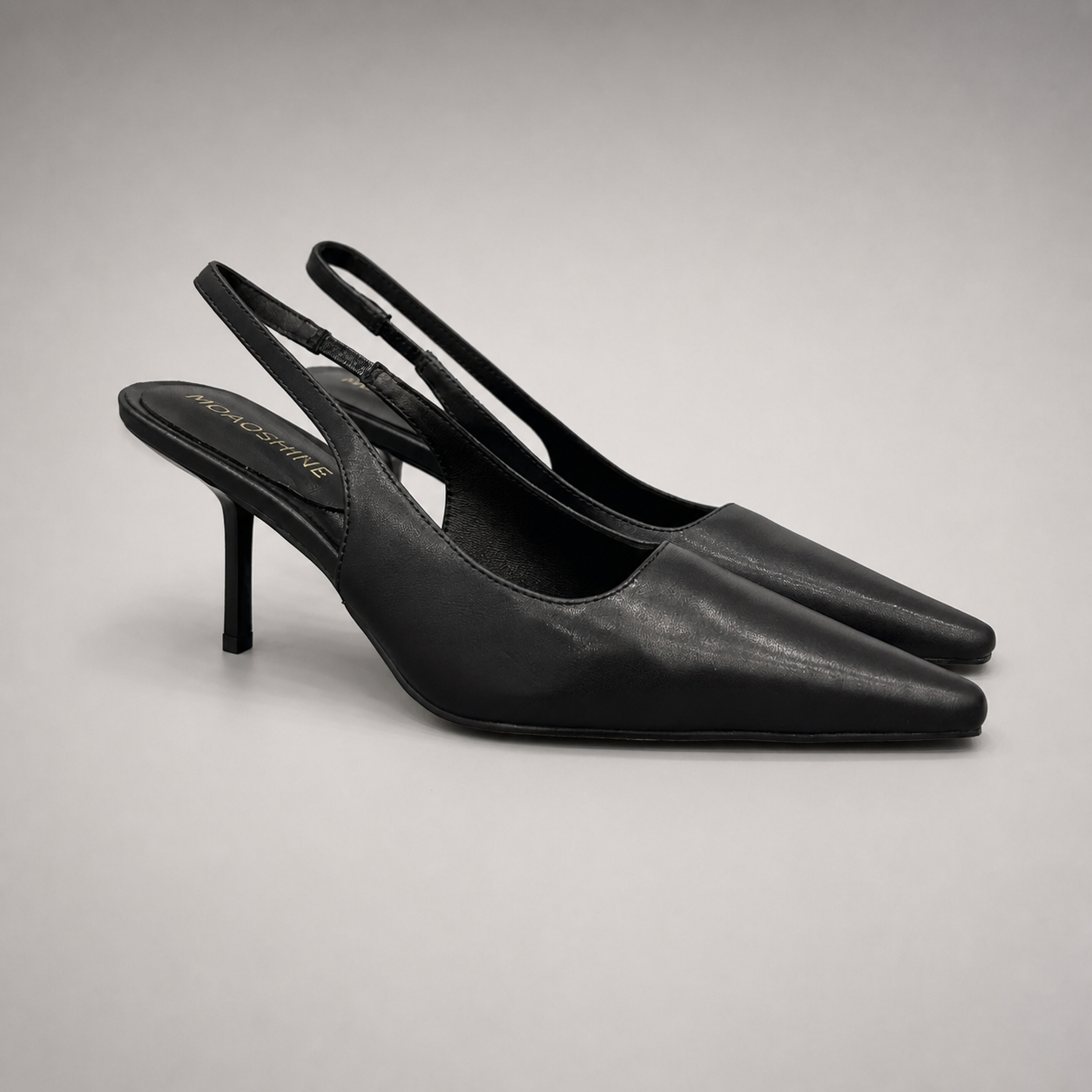 Black slingback pump pair three-quarter view showing a pointed toe