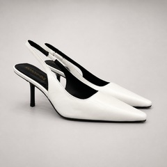 White slingback pump pair three-quarter view showing a pointed toe, angular side cutout, and slingback strap