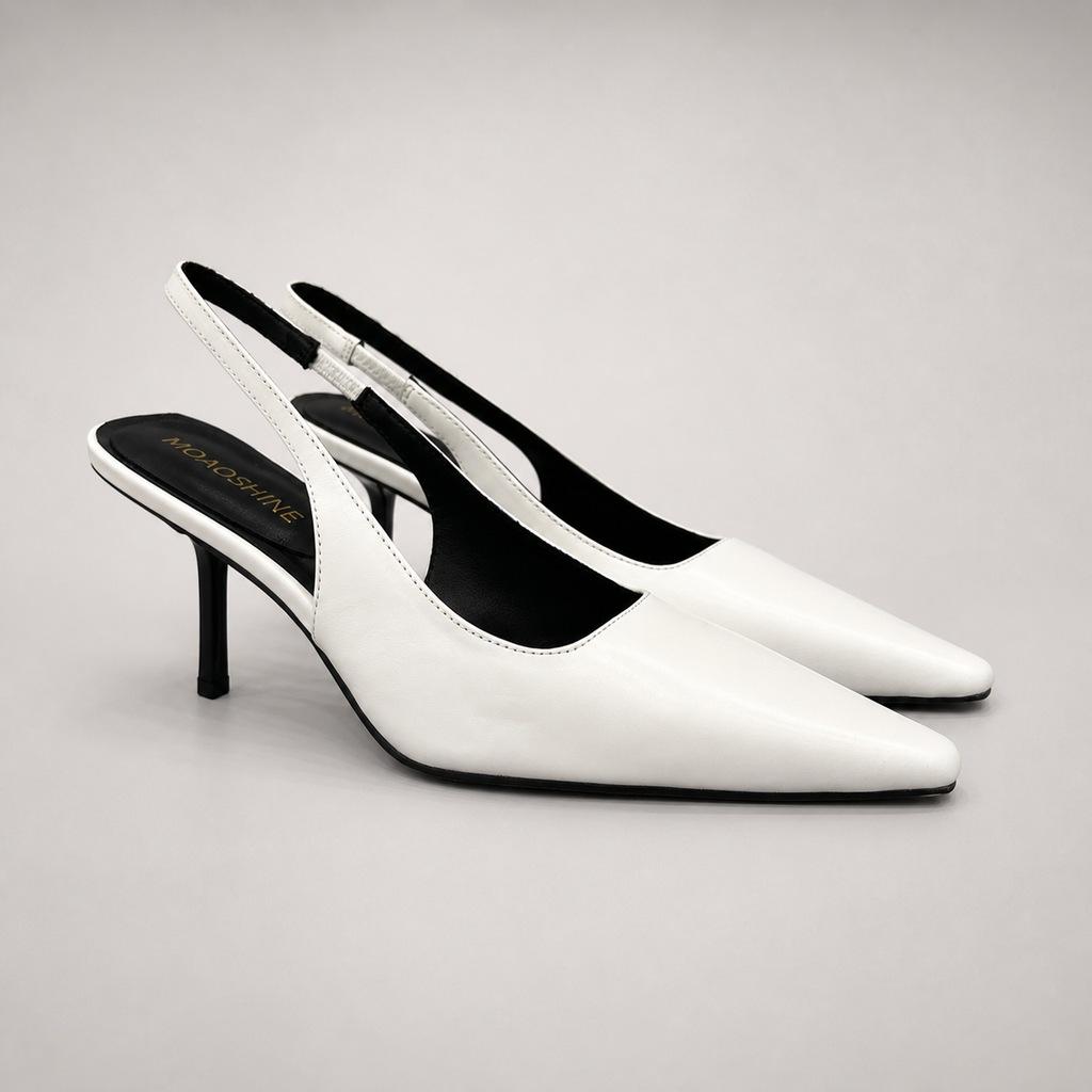 White slingback pump pair three-quarter view showing a pointed toe, angular side cutout, and slingback strap