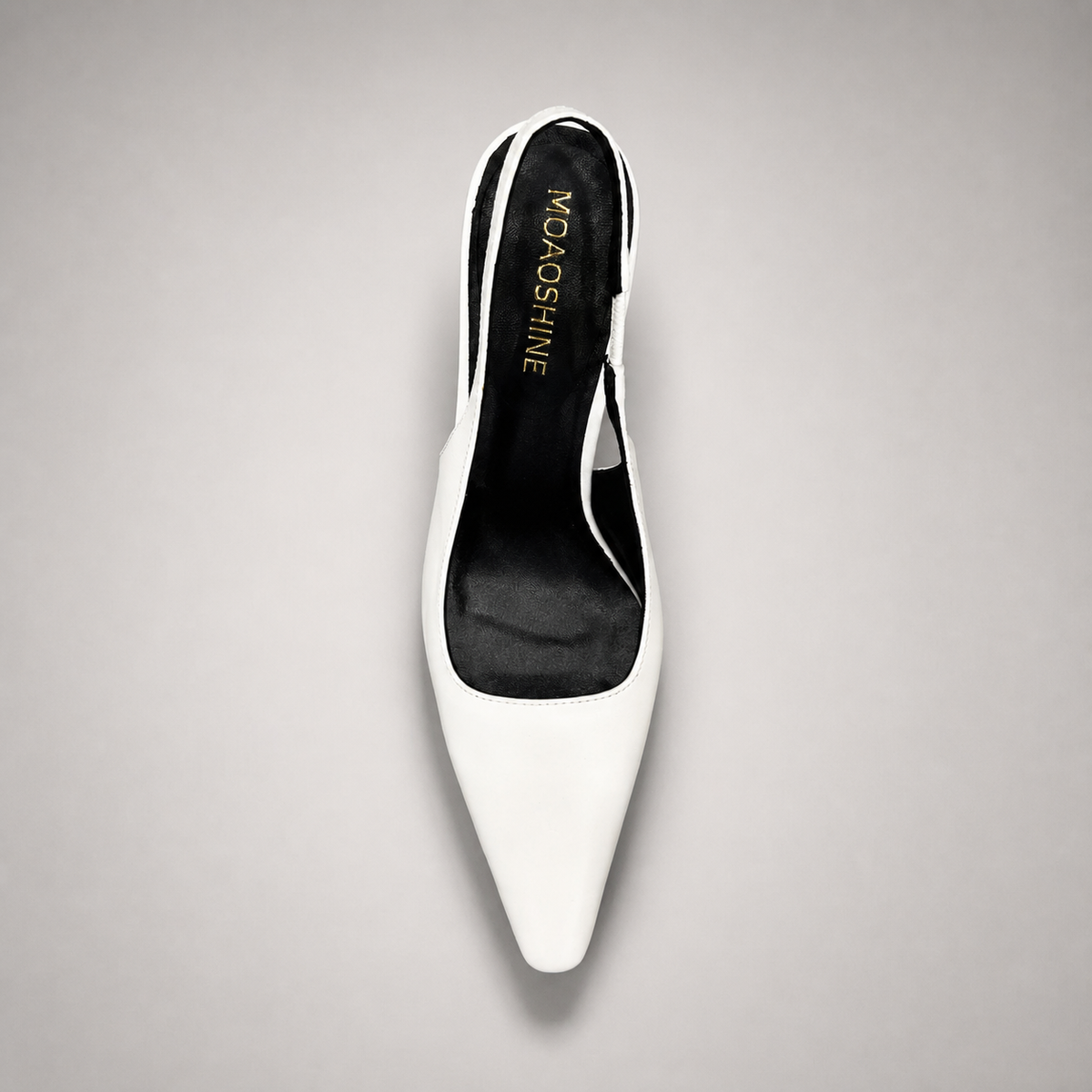 White slingback pump top view showing a pointed toe, angular side cutout, and slingback strap