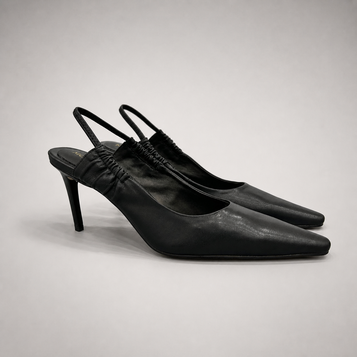 Black slingback pump pair three-quarter view showing a pointed toe