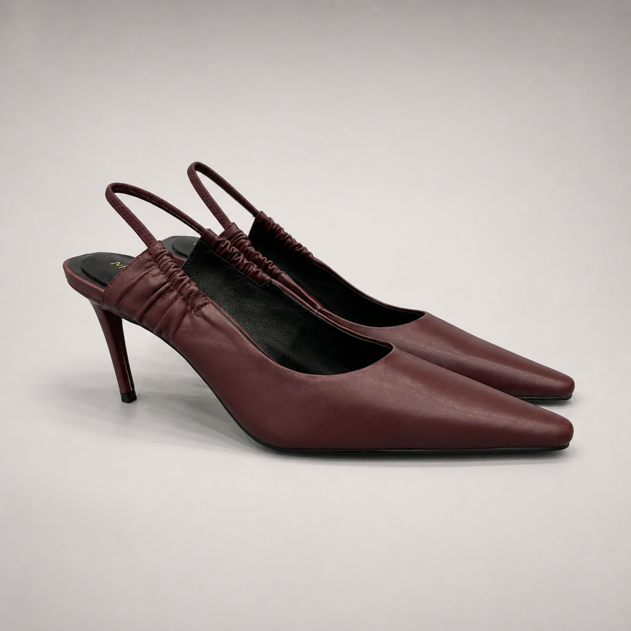 Burgundy slingback pump pair three-quarter view showing a pointed toe and gathered slingback strap