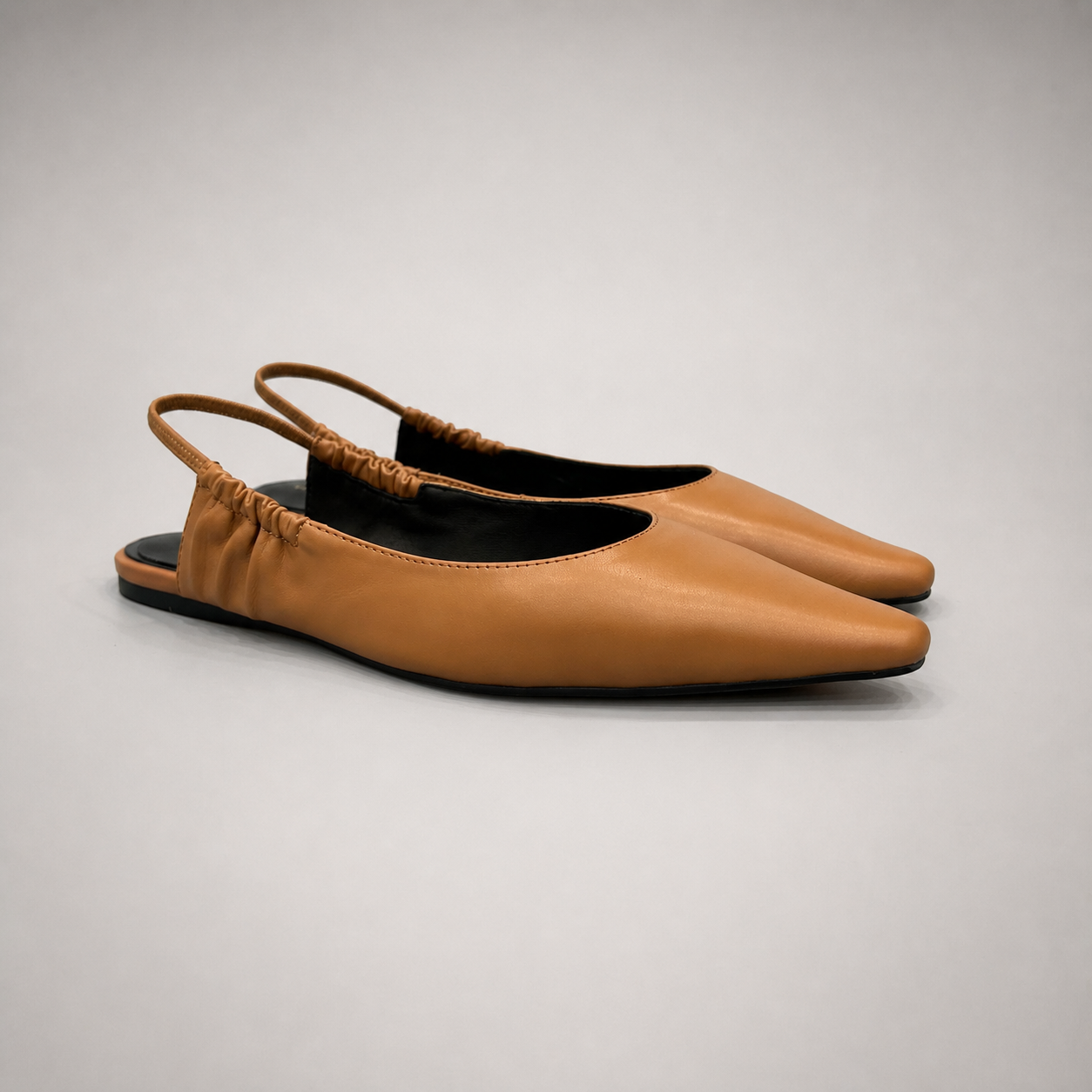 Tan slingback flat pair three-quarter view showing a square toe and gathered slingback strap