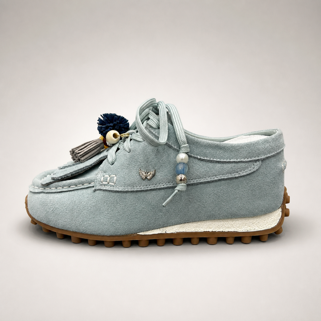Light Blue moccasin sneaker side profile showing fringe and tassel details over the laces