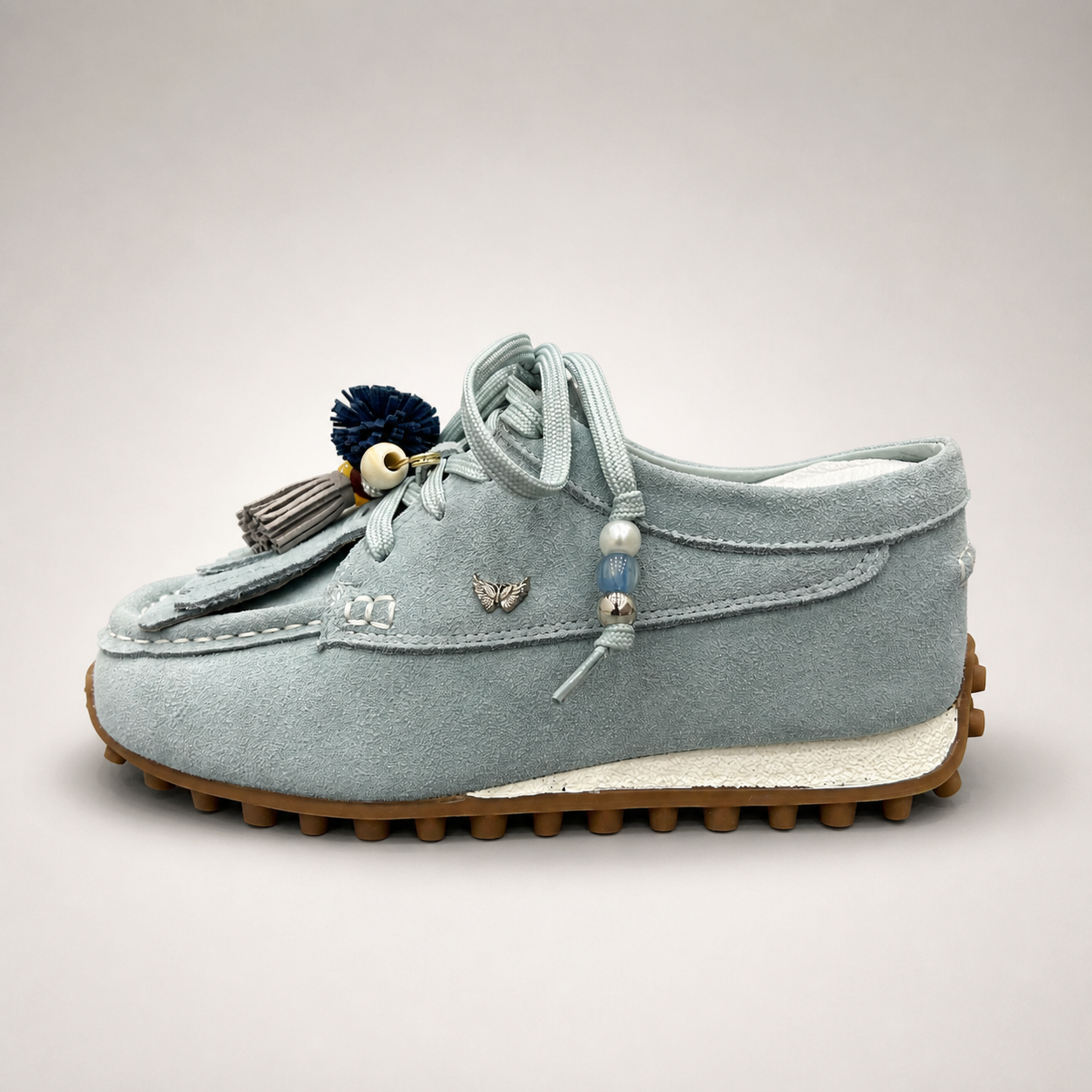 Light Blue moccasin sneaker side profile showing fringe and tassel details over the laces