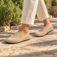 Beige calf suede slip-on mules worn outdoors