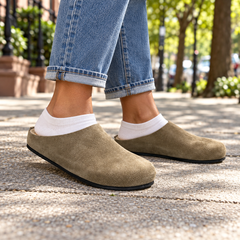 Taupe calf suede slip-on mules worn outdoors
