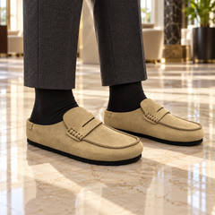 Beige calf suede penny-loafer mules worn outdoors