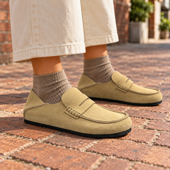 Beige calf suede penny loafers worn outdoors