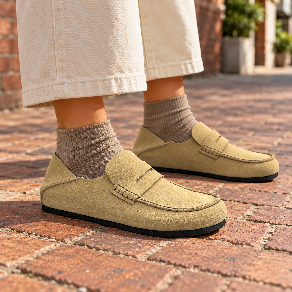 Beige calf suede penny loafers worn outdoors