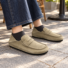 Taupe calf suede penny loafers worn outdoors
