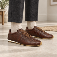 Brown eel-embossed oil-waxed leather low-profile sneakers worn with charcoal trousers and oatmeal socks