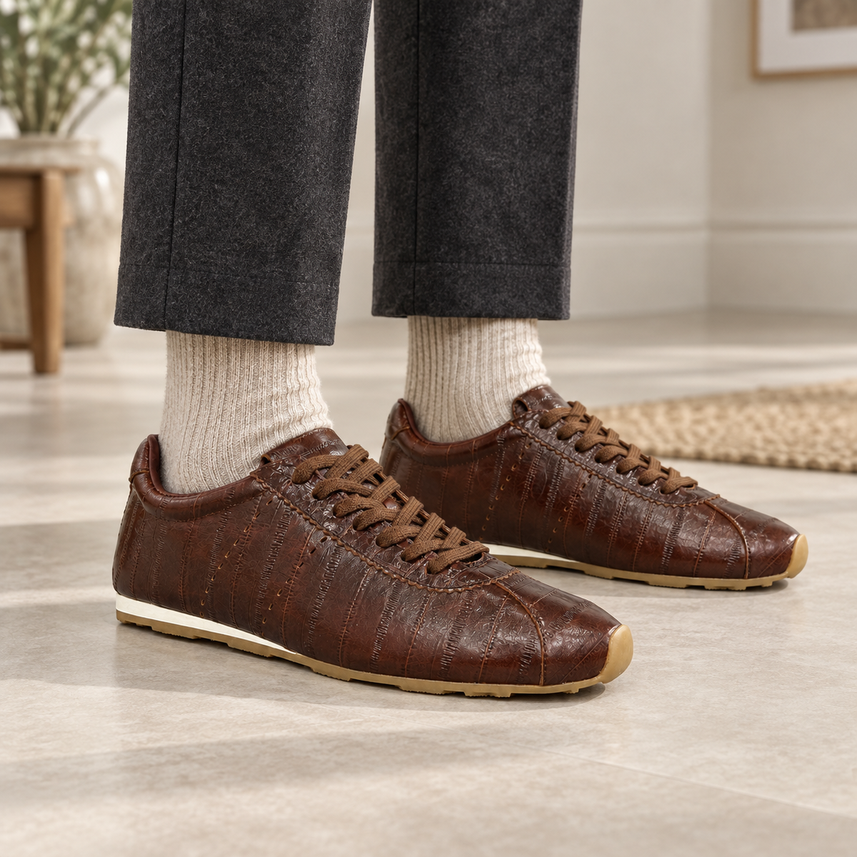 Brown eel-embossed oil-waxed leather low-profile sneakers worn with charcoal trousers and oatmeal socks